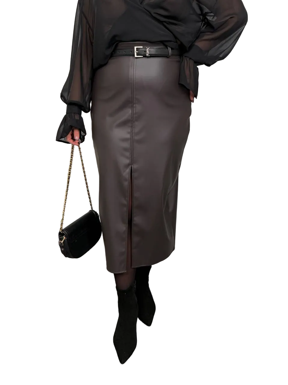 Person wearing a black leather skirt with a black top and black shoes on a white background