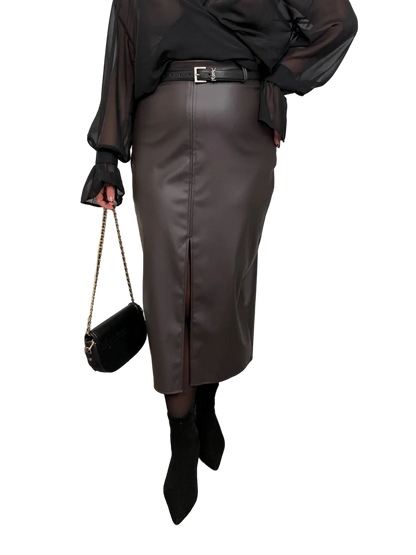 Person wearing a black leather skirt with a black top and black shoes on a white background