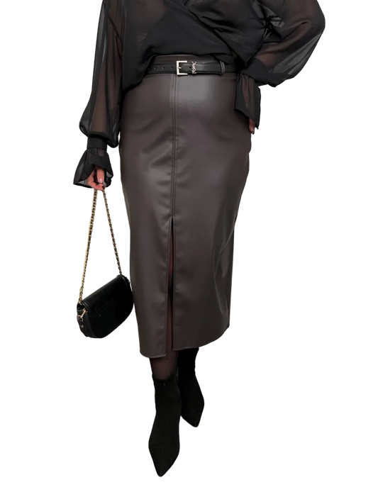 Person wearing a black leather skirt with a black top and black shoes on a white background