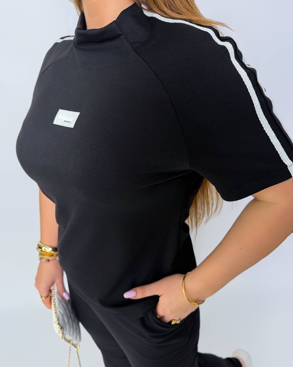 Black outfit with white stripes on a plain background