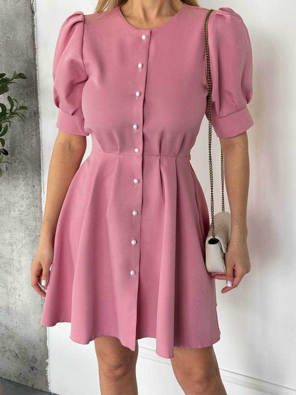 Pink dress with puff sleeves worn by a person against a neutral background