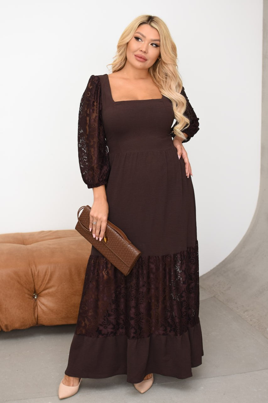 Woman wearing a brown dress with lace details, holding a matching clutch, against a white background.