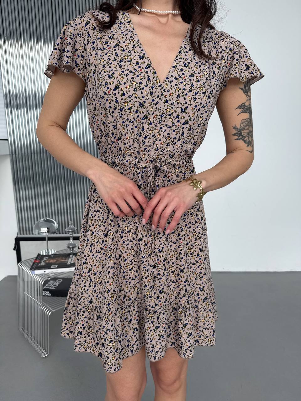 Woman wearing a floral dress in an indoor setting