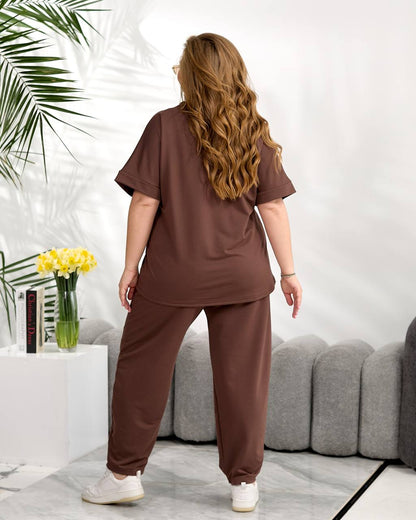 Person wearing a brown outfit standing in a modern living room.