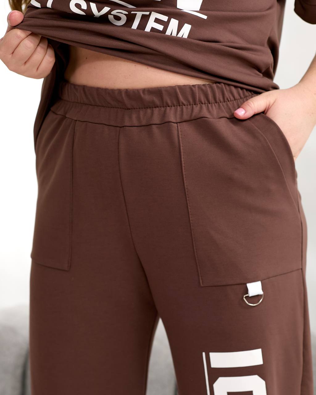 Brown pants with pockets and a visible brand logo on a neutral background