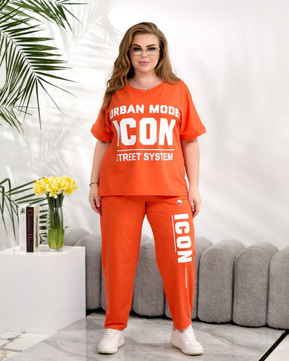 Woman wearing an orange 'ICON' branded outfit in a modern living room.