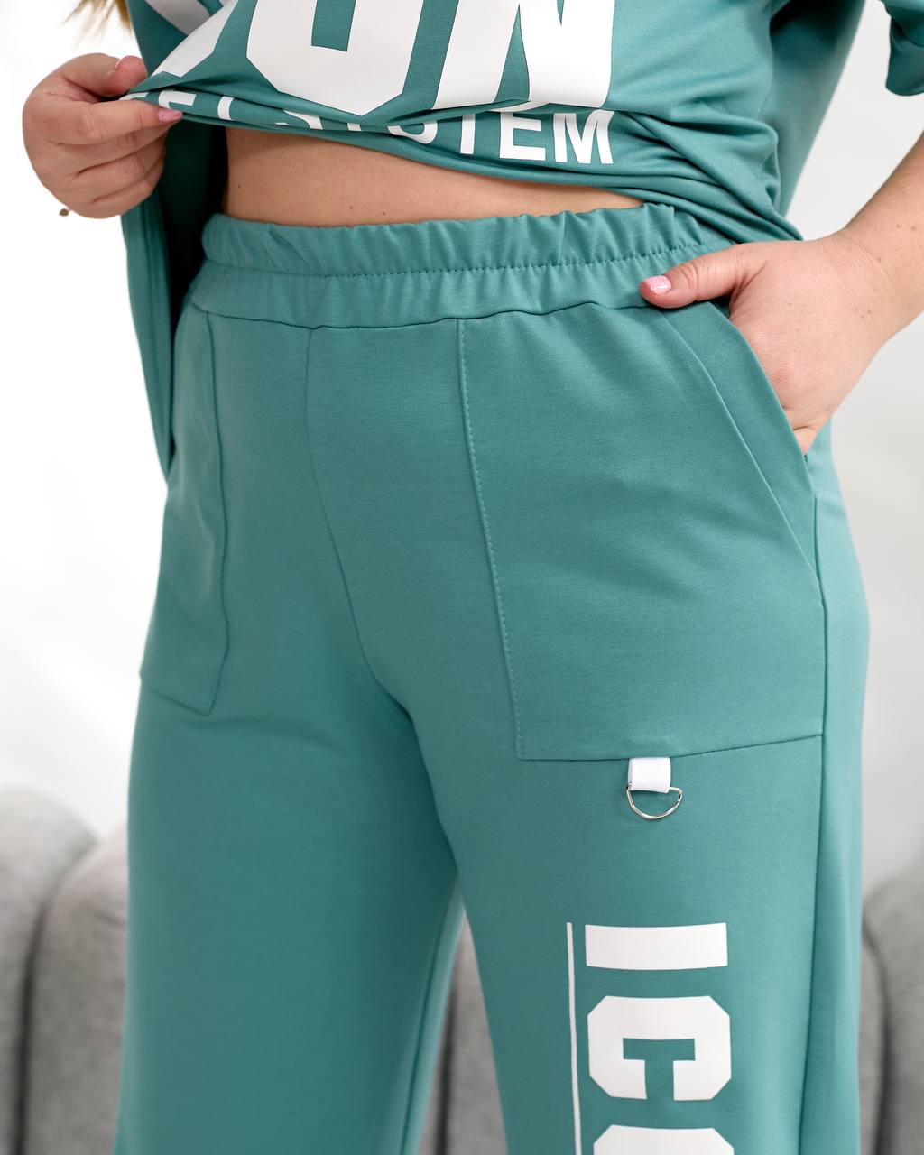 Teal tracksuit with white text on a neutral background