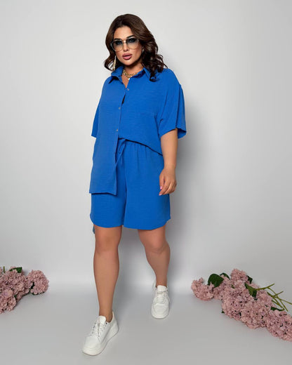 Woman wearing a blue outfit with sunglasses on a white background