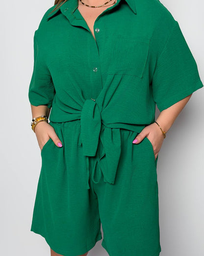 Green romper worn by a person on a light gray background