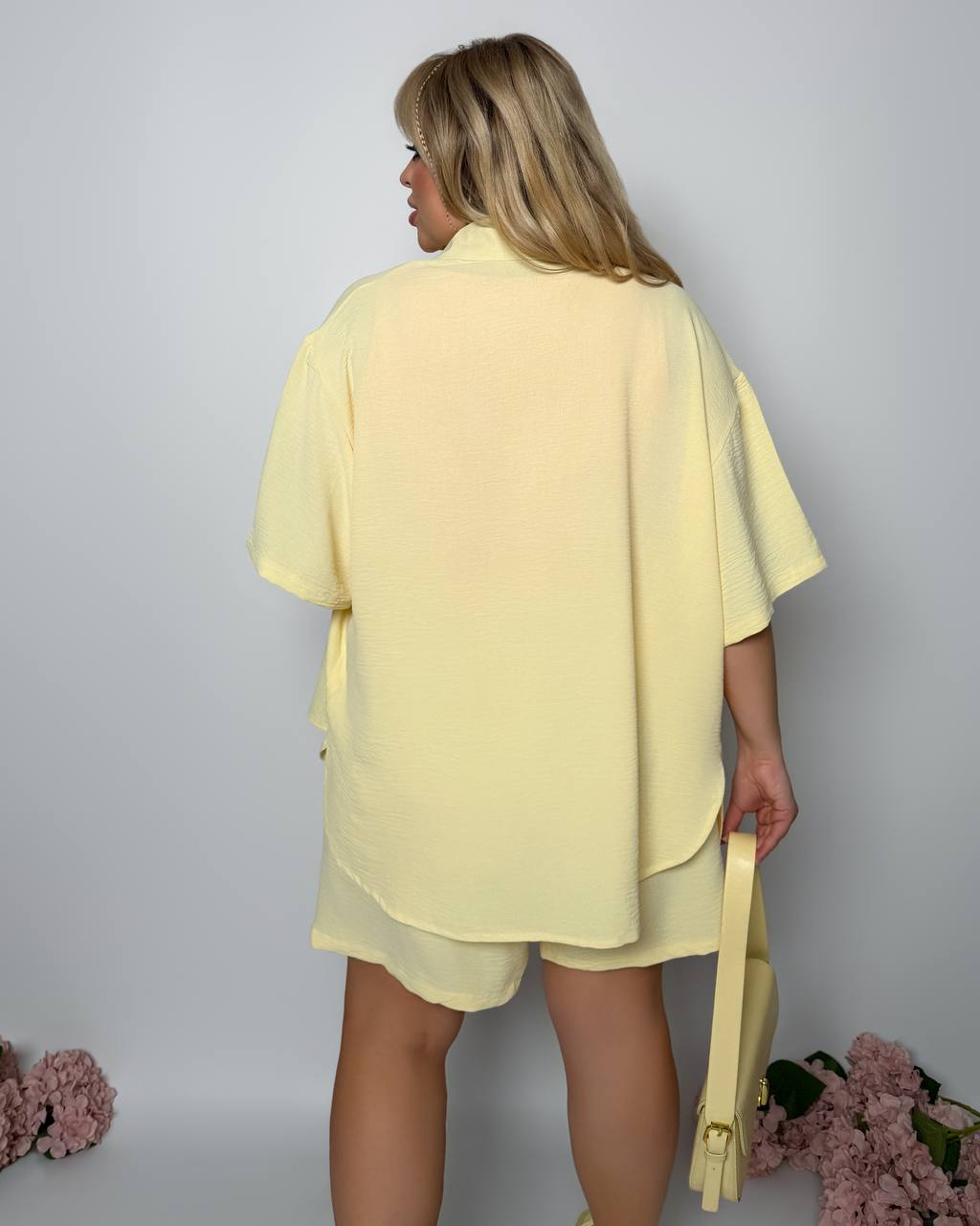 Person wearing a yellow outfit with a plain background