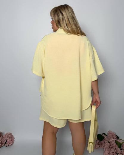 Person wearing a yellow outfit with a plain background