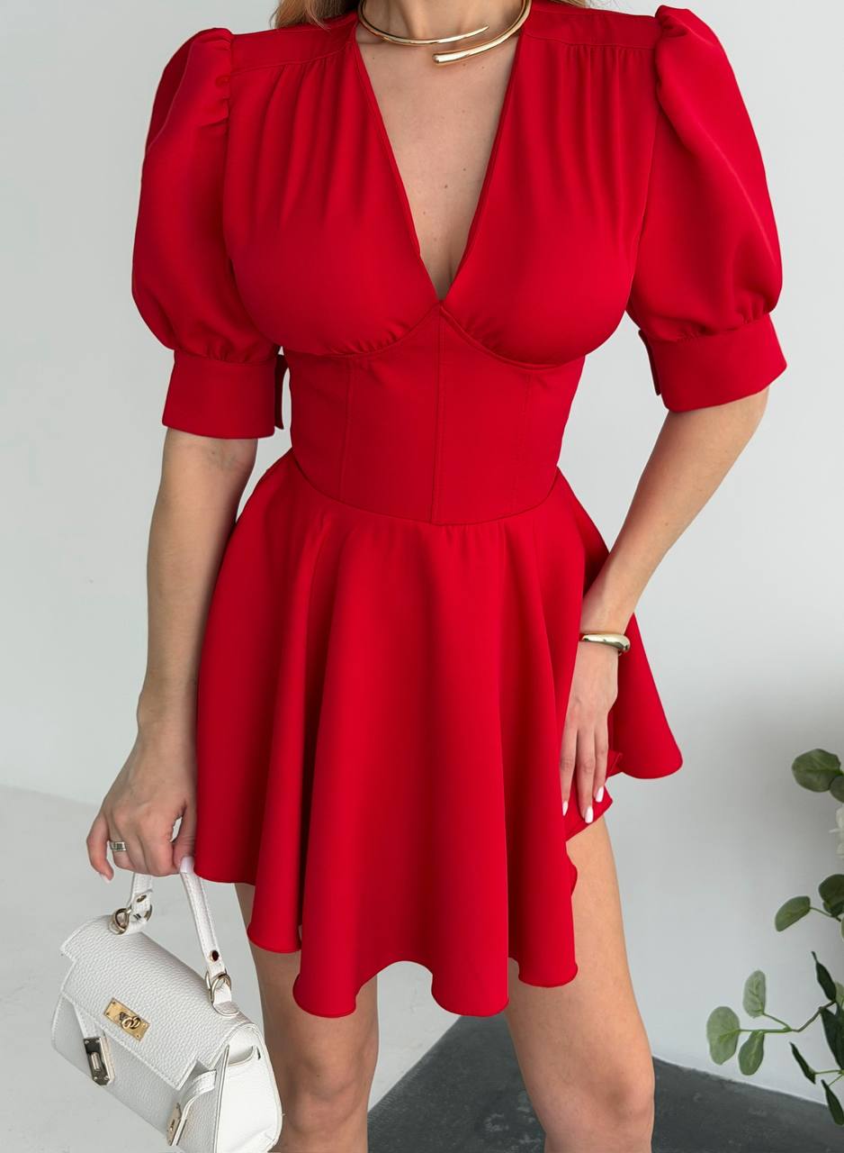 Red dress with puff sleeves worn by a person on a plain background