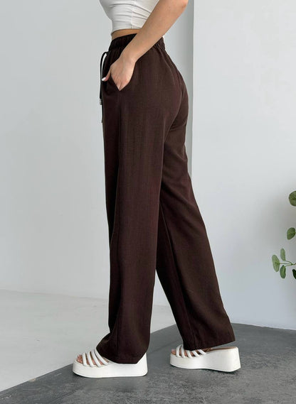 Brown wide-leg pants worn by a person on a neutral background
