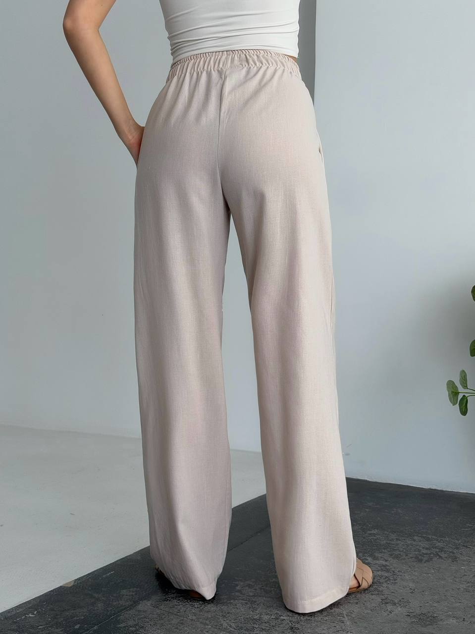 Beige wide-leg pants worn by a person on a plain background