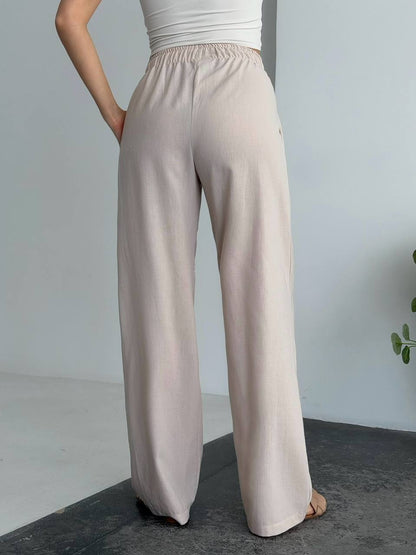 Beige wide-leg pants worn by a person on a plain background