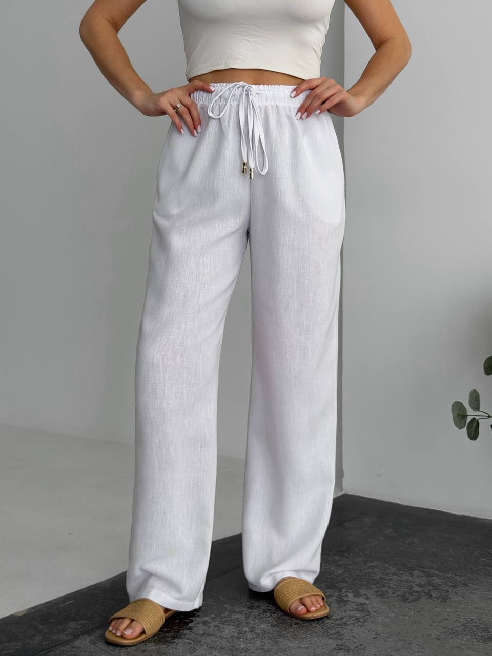 Person wearing white pants with a plain background