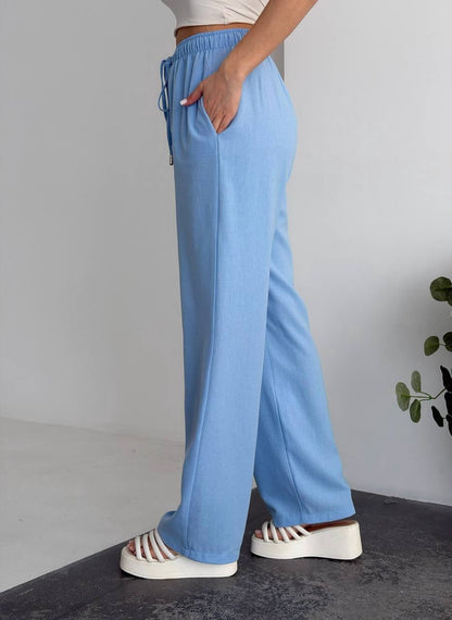 Person wearing light blue pants with a neutral background