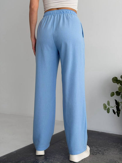 Person wearing light blue pants with a plain background