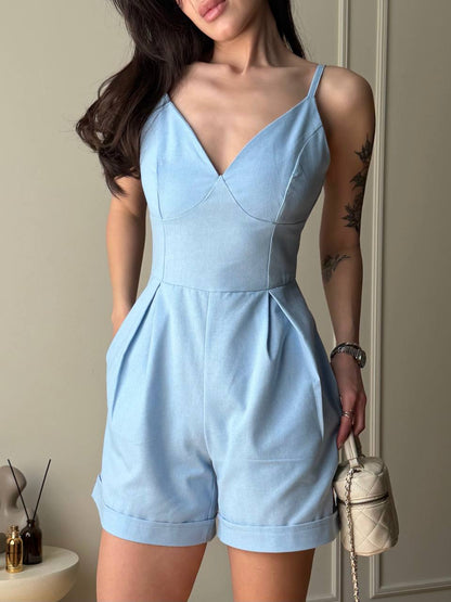 Woman wearing a light blue romper with a neutral background
