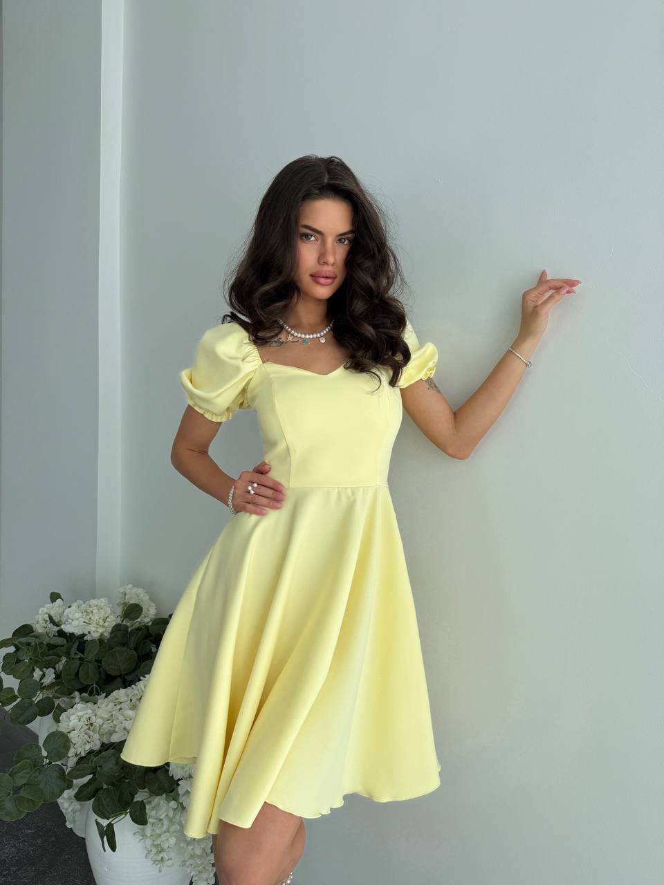 Woman wearing a yellow dress against a plain background