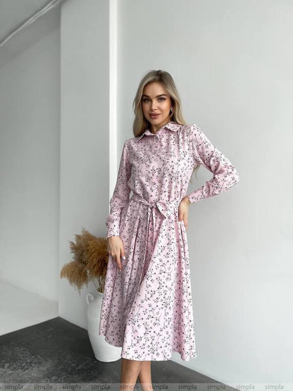 Woman wearing a pink floral dress in a minimalistic setting