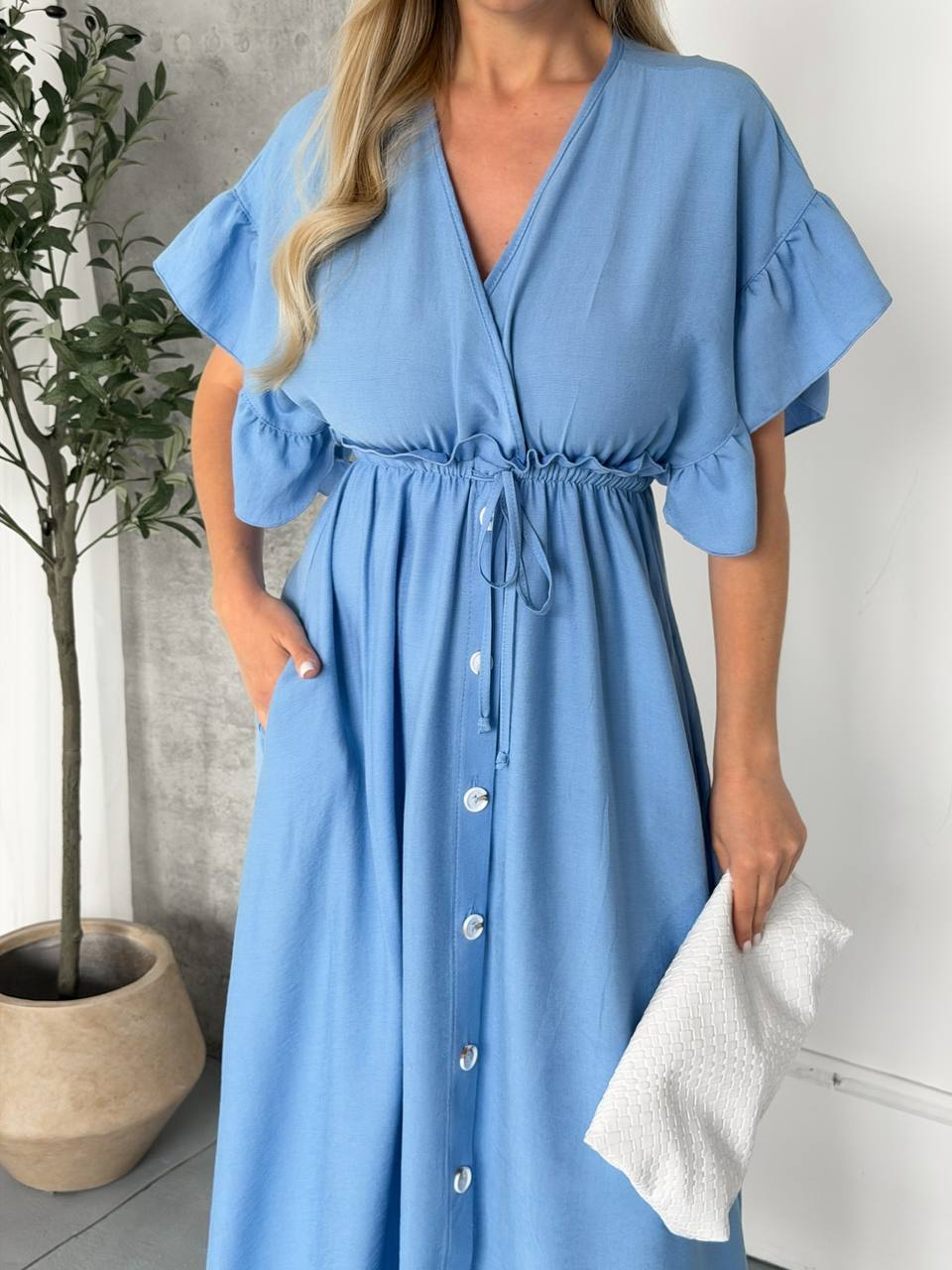 Woman wearing a blue dress with a white background