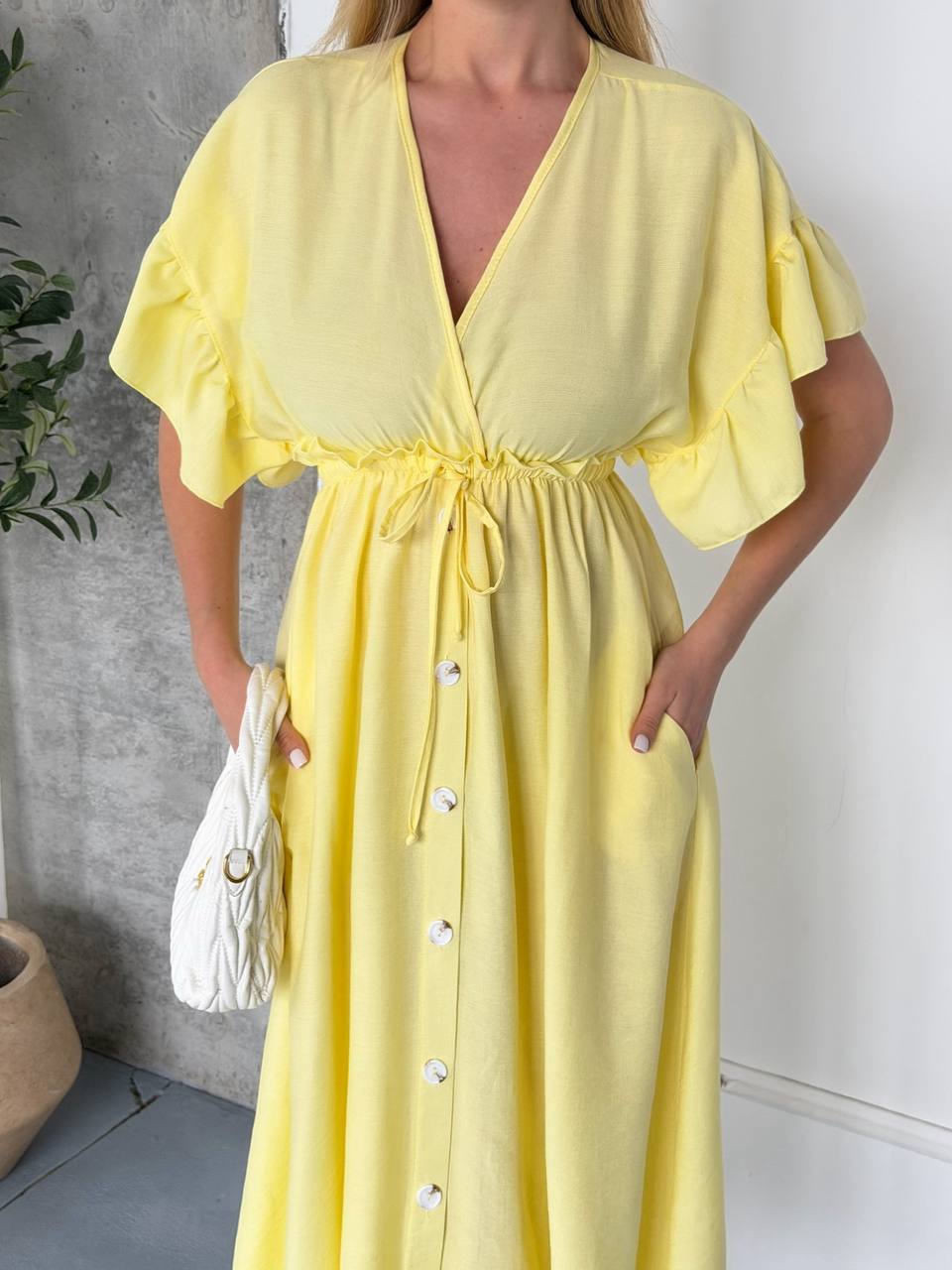 Woman wearing a yellow dress with a white background