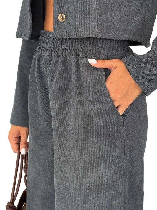 Gray corduroy pants with a hand in the pocket on a white background