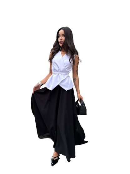 Woman wearing a white top and black skirt with a handbag on a white background