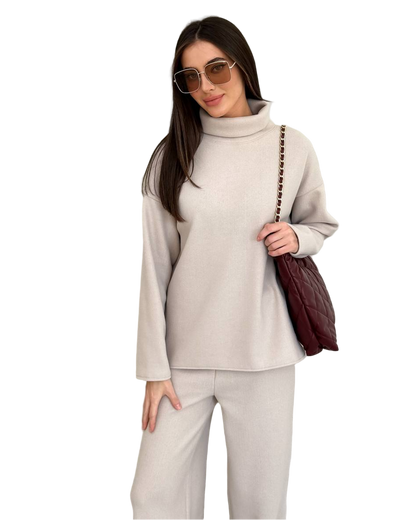 Woman wearing a beige outfit with sunglasses and a brown bag on a white background