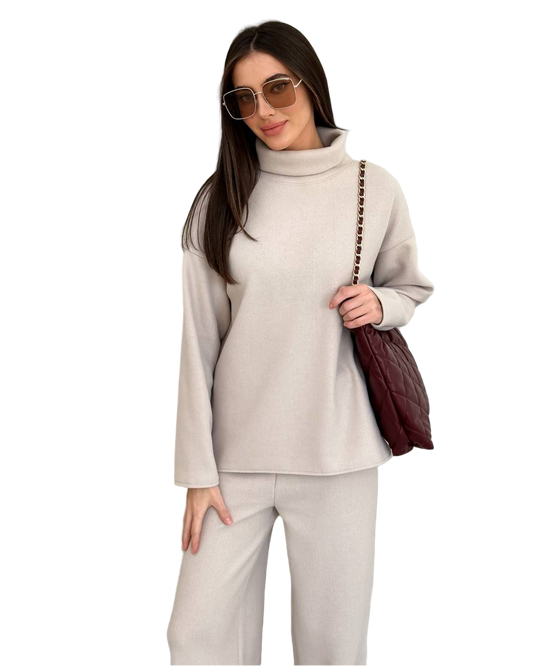 Woman wearing a beige outfit with sunglasses and a brown bag on a white background