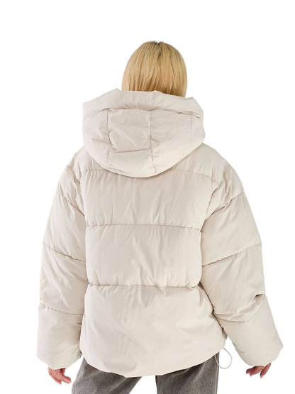 Person wearing a beige puffer jacket on a white background