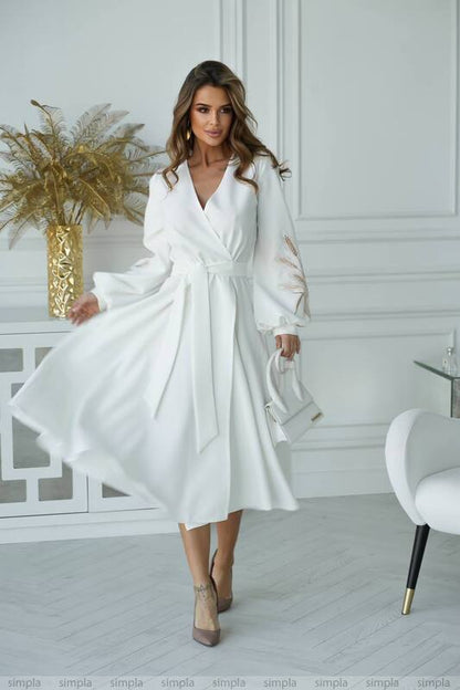 Woman wearing a white dress in a stylish room with decor elements.