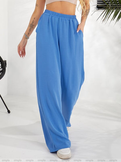 Person wearing blue wide-leg pants on a white background