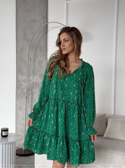 Woman wearing a green floral dress in a modern interior setting