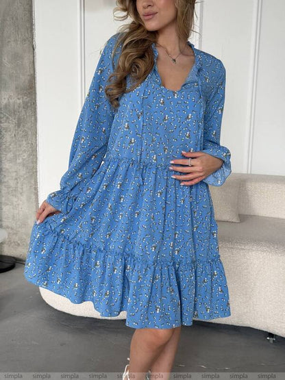 Woman wearing a blue floral dress in an indoor setting