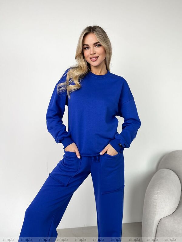Woman wearing a blue tracksuit against a white background