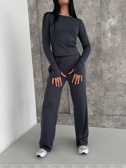 Person wearing a dark gray athletic outfit against a neutral background