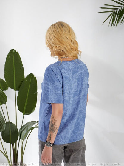 Person wearing a blue t-shirt with plants on a white background