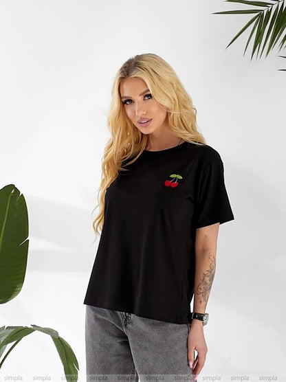 Woman wearing a black t-shirt with a red cherry design against a white background