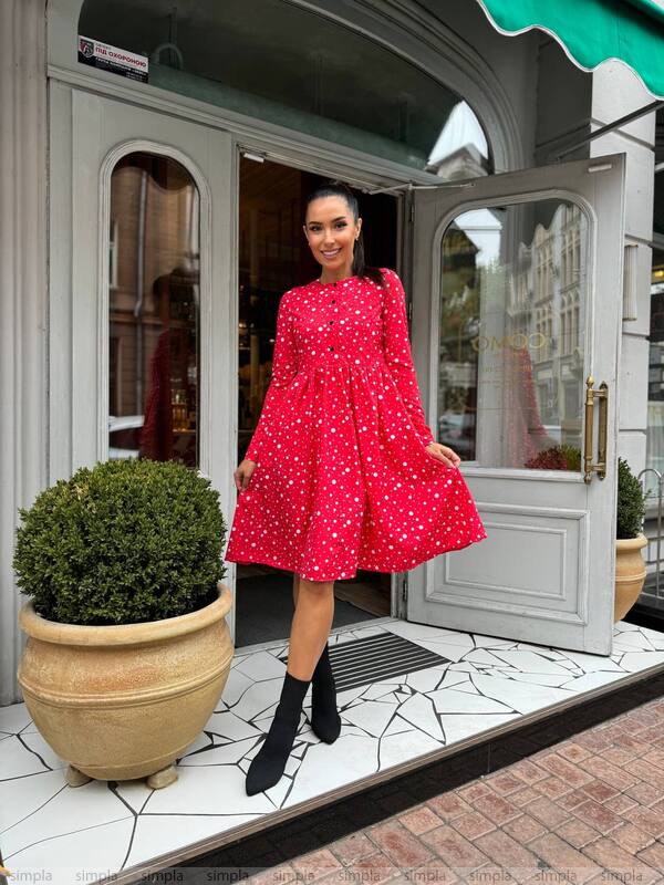 Woman in a red dress standing outside a store entrance