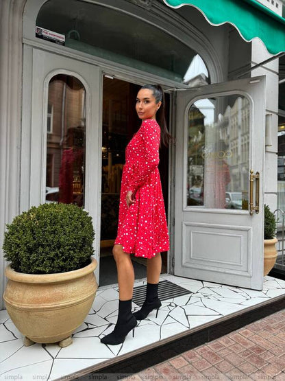 Woman in a red dress standing in front of a store entrance