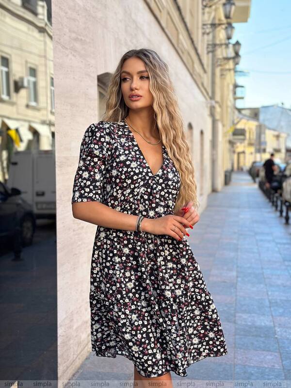 Woman in a floral dress standing on a city street