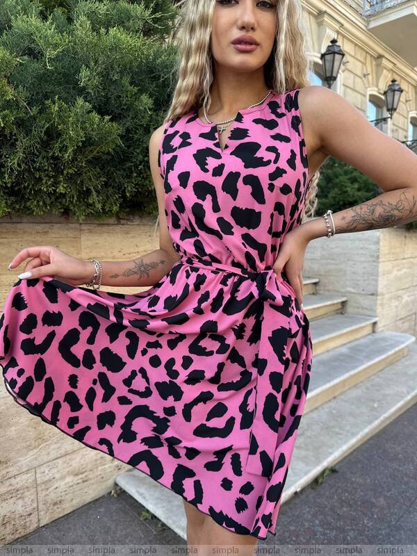 Woman wearing a pink leopard print dress outdoors.