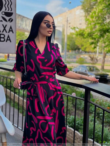Woman in a black and pink dress standing on a balcony with a cityscape background