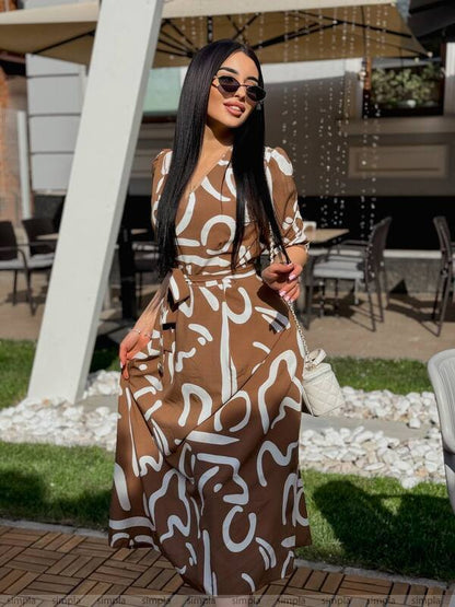 Woman wearing a brown and white patterned dress outdoors.