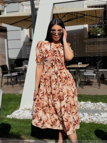 Woman in a floral dress standing outdoors with a blurred background