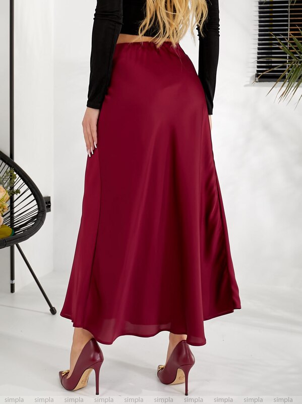 Person wearing a burgundy skirt with a plain background