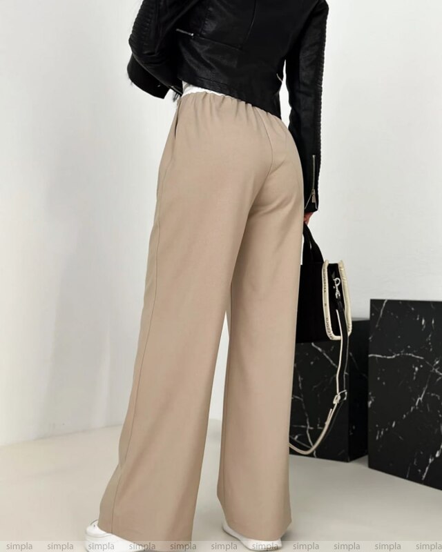 Beige wide-leg pants worn with a black top on a white background