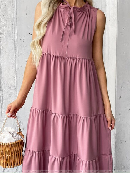 Woman wearing a pink dress holding a basket against a light gray background